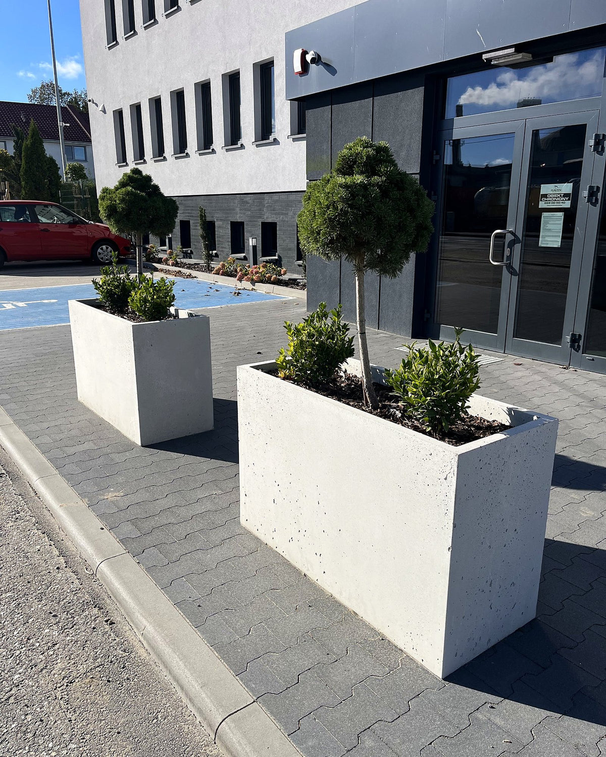 Donice Forma 120/75 z drzewkami przed budynkiem biurowym – realizacja